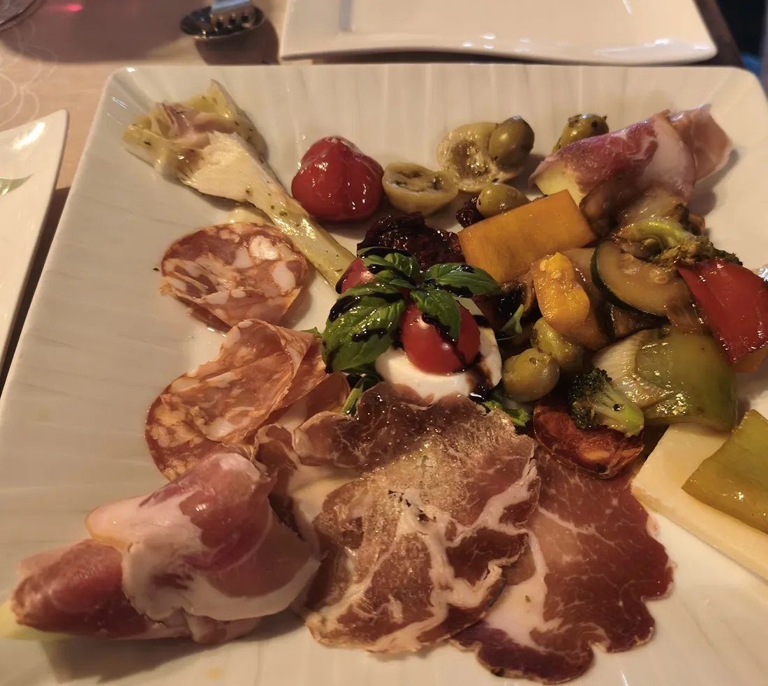 Antipasti-Teller mit Schinken, Salami, Oliven und gegrilltem Gemüse